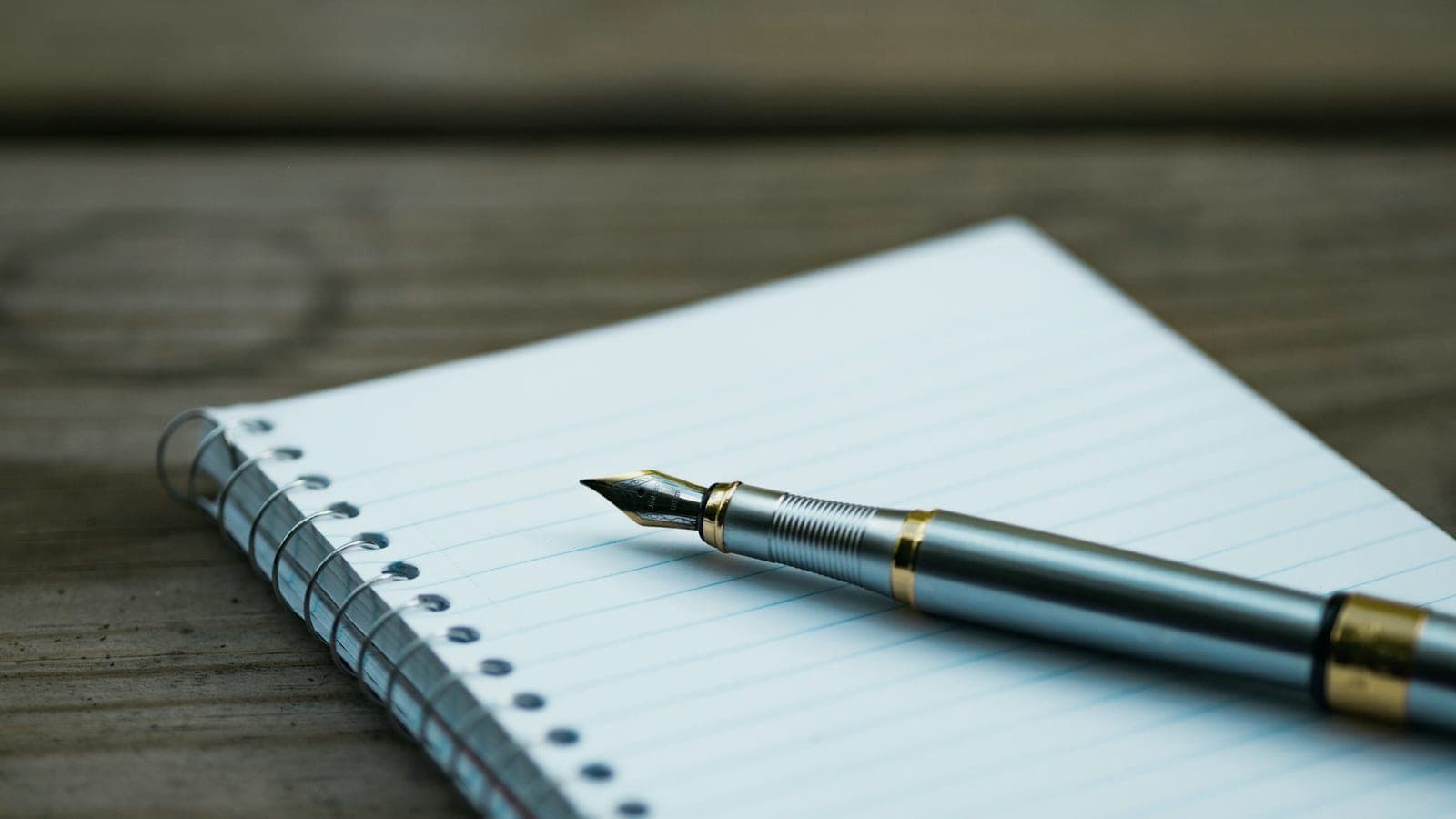 Caneta-tinteiro sobre um caderno espiral aberto